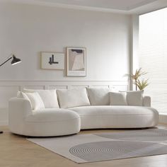 a large white couch sitting in a living room next to a lamp