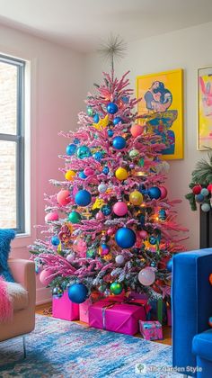 a brightly colored christmas tree in the corner of a room with blue and pink furniture