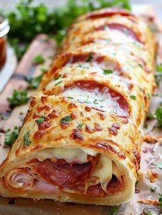 a close up of a pizza roll on a cutting board with sauce and parsley