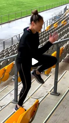 a woman doing tricks on a skateboard in front of an empty bleachers