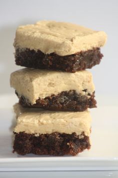 three brownies stacked on top of each other with frosting in the middle and one cut in half