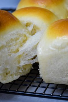 a close up of some bread on a cooling rack with it's buns cut in half