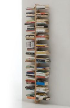 a book shelf made out of books on top of a white wall next to a gray wall