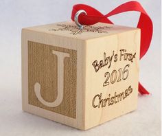 a baby's first christmas block ornament with the letter j on it