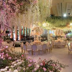 an elaborately decorated banquet hall with flowers and chandeliers hanging from the ceiling