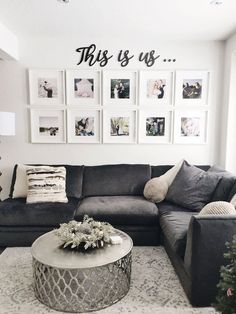 a living room with grey couches and pictures on the wall above it, along with a coffee table