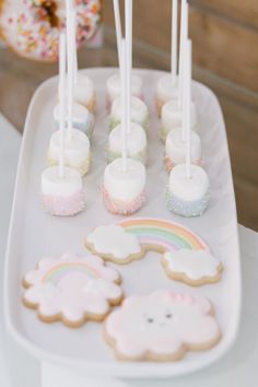 there are many cookies and marshmallows on the tray with candles in them