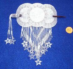 a white beaded table runner on blue carpet