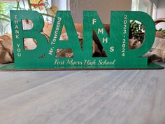 a wooden sign with the word band on it sitting on top of a wood table