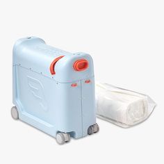 a blue and orange suitcase next to a roll of toilet paper