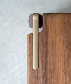 a close up of a door handle on a wooden cabinet