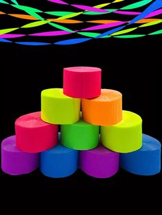 a stack of brightly colored plastic cups sitting on top of each other in front of a black background