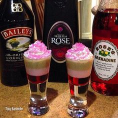 two glasses filled with ice cream next to bottles of booze