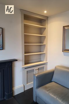 a living room with a couch, fireplace and bookshelf next to the wall