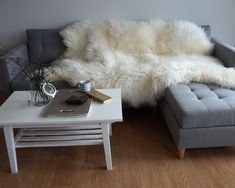 a living room with a couch, coffee table and rug on the floor in front of it