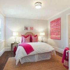 a bedroom with white walls and pink accents