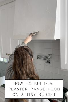 a woman is fixing the hood on a kitchen stove with text overlay that reads how to build a plaster range hood on a tiny budget