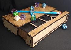 a wooden box with dice and pencils on it