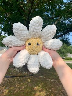 someone is holding up a crocheted flower that looks like it has been made from yarn