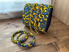 Welcome to Amariru creations!  This listing is for Small African print fabric purse/clutch bag in yellow/gold fabric with two bracelets . Handcrafted from cotton wax print fabric and machine stitched with a professional finish.  Dimensions: Purse - 6.5 inches by 6 inches Chain - 50 inches. Note: Fabric placement may vary slightly than what's pictured. This gives each pair a unique look just for you.  Computer monitors and cell phone screens may make colors appear lighter/darker than actual item. All items are carefully handmade in a clean and smoke free home. I work strenuously to ensure that every Amariru Creations accessories are made to perfection. Africa Print, Ankara Bags, Fabric Purse, Fabric Purses, Printed Purse, Phone Screens, African Print Fabric, Gold Fabric, Functional Accessories