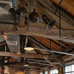 the ceiling is covered in exposed pipes and lights