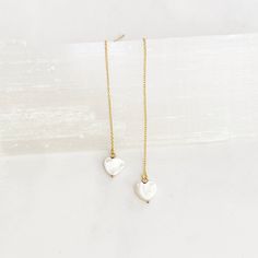 These super cool earrings are versatile and lightweight. They feature a tiny 8mm white mother of pearl hand carved heart that dangles from 3” of 14kt gold filled threader chain including the post. Simply push the post through the pierced hole and pull through to desired length. They come with a rubber stopper so can also be worn as a long dangle post earring once the stopper is put on the post. Cool Earrings, Carved Heart, Pearl Heart, Pull Through, Threader Earrings, 14kt Gold, Post Earrings, Mother Of Pearl, Gold Filled