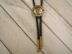 Complete your look with this Western Southwestern Concho Polished Brass Bolo Tie. The Unisex, Unique Design will make you Standout everywhere.. -  Perfect gift for Her, Him, Yourself,...Valentines Day, Christmas, Birthday, Anniversary, and more -  Affordably Priced and always in style -  Southwestern Native American Inspired Concho Bolo Tie,  -  *Medium Sized Pendant*, -  Hand Polished Brass with an Antiqued Finish, -  Anti-Tarnish added for longer Lasting Beauty,  - 30 TO 42 inch, Genuine Black Adjustable Gold Western Bolo Ties, Gold Western Bolo Tie, Adjustable Western Gold Jewelry, Adjustable Gold Western Jewelry, Western Style Gold Lariat Jewelry, Adjustable Gold Concho Jewelry, Ceremonial Antique Gold Adjustable Jewelry, Elegant Concho Jewelry For Western-themed Events, Vintage Adjustable Jewelry For Western-themed Events