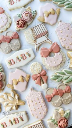 baby shower cookies are laid out on a white surface with pink and gold decorations around them