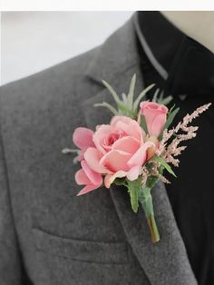 a boutonniere with pink flowers on the lapel of a man's suit