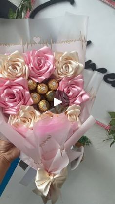 someone is holding a bouquet of roses and chocolates