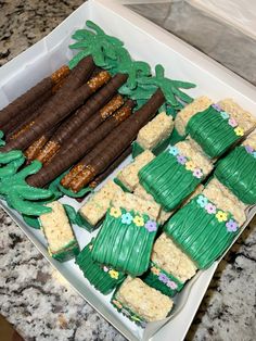 a box filled with lots of green and brown desserts on top of a counter