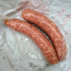 two sausages are wrapped in plastic on the table