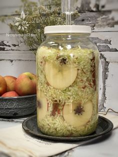 a glass jar filled with sliced apples on top of a table