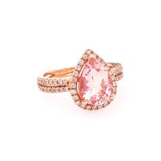 an engagement ring with a pink stone surrounded by diamonds