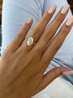 a woman's hand with a ring on it and a diamond in the middle