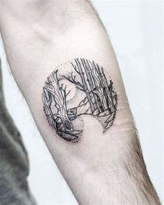 a man's arm with a small black and white tattoo on the left forearm