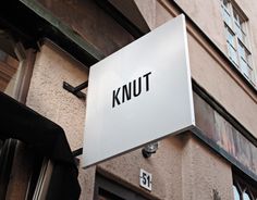 a sign on the side of a building that says knut next to a doorway