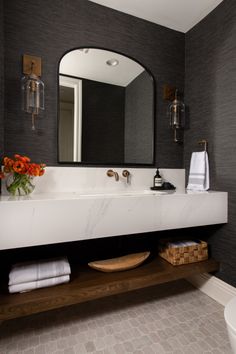 a white sink sitting under a large mirror in a bathroom