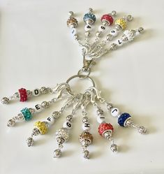 a bunch of charms that are sitting on a white surface with the words bead love spelled in them