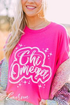 a blonde woman wearing a pink shirt with the words oh omega on it