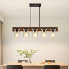 a dining room table with four chairs and a light fixture hanging from it's ceiling