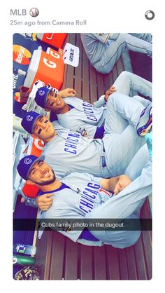 two baseball players are sitting in the dugout