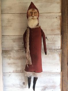 an old fashioned santa clause doll hanging on the wall