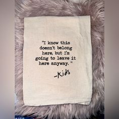 a white tea towel with the words kids on it sitting on a pile of books