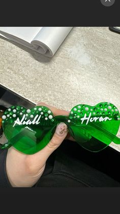 a person is holding some green glasses with the words hello hope written on them in white letters