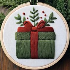 a cross stitch ornament with a gift box on it