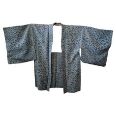 This is a silk jacket which was made in Japan. It was made in Showa era around 1980s. The haori is a traditional Japanese hip- or thigh-length jacket worn over a kimono. Resembling a shortened kimono with no overlapping front panels (okumi), the haori typically features a thinner collar than that of a kimono, and is sewn with the addition of two thin, triangular panels at either side seam. The haori is usually tied at the front with two short cords, known as haori himo, which attach to small loo Japanese Jacket, Haori Jacket, Shibori Techniques, Showa Era, Grey Flowers, Japanese Silk, Silk Jacket, Japanese Antiques, White Silk