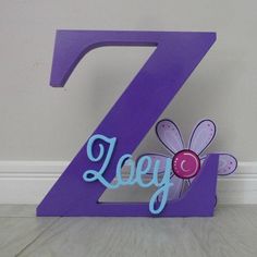 the number seven has a purple flower on it and is next to a white wall