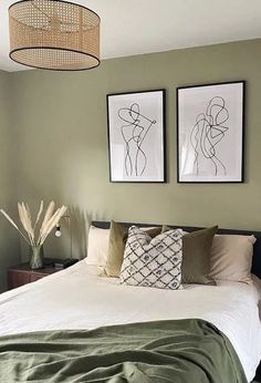 a bedroom with two pictures on the wall above the bed