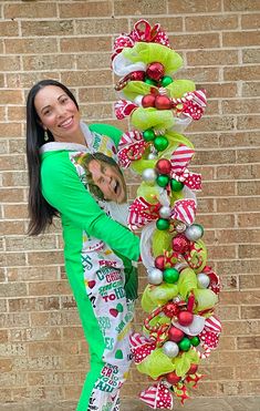 a woman standing next to a tall christmas tree